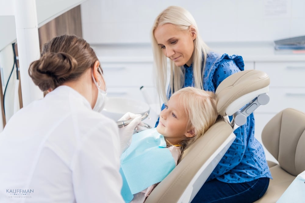 a mother watching an orthodontist taking care of her little daughters teeth after given an explanation about how to fix overbite in new braunfels, tx