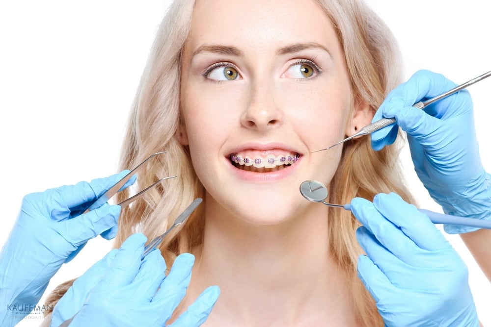 Orthodontist examining a young woman with braces during a dental checkup – braces for overbite in New Braunfels, TX